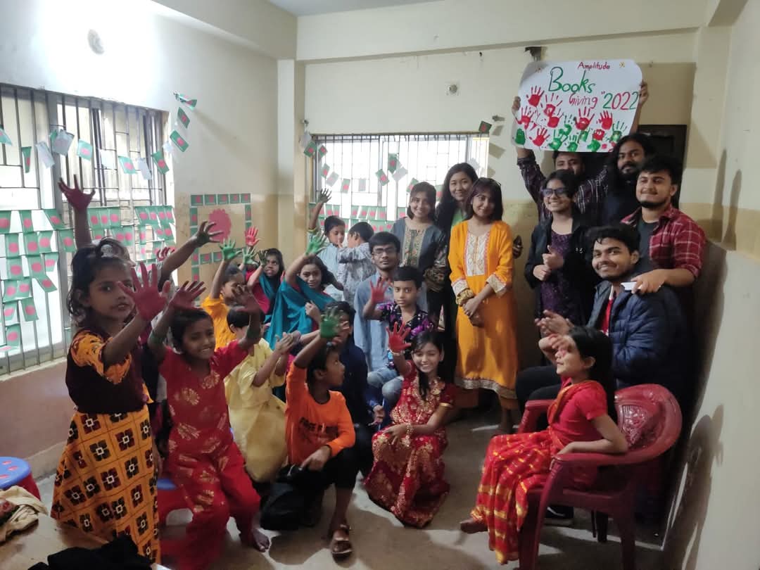 Amplitude volunteers distributing books to children